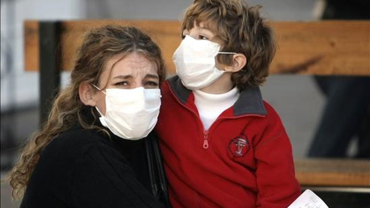 Una mujer y su hijo utilizan tapabocas como medida preventiva contra la gripe A mientras esperan para ser atendidos en un hospital de Buenos Aires. EFE/Archivo