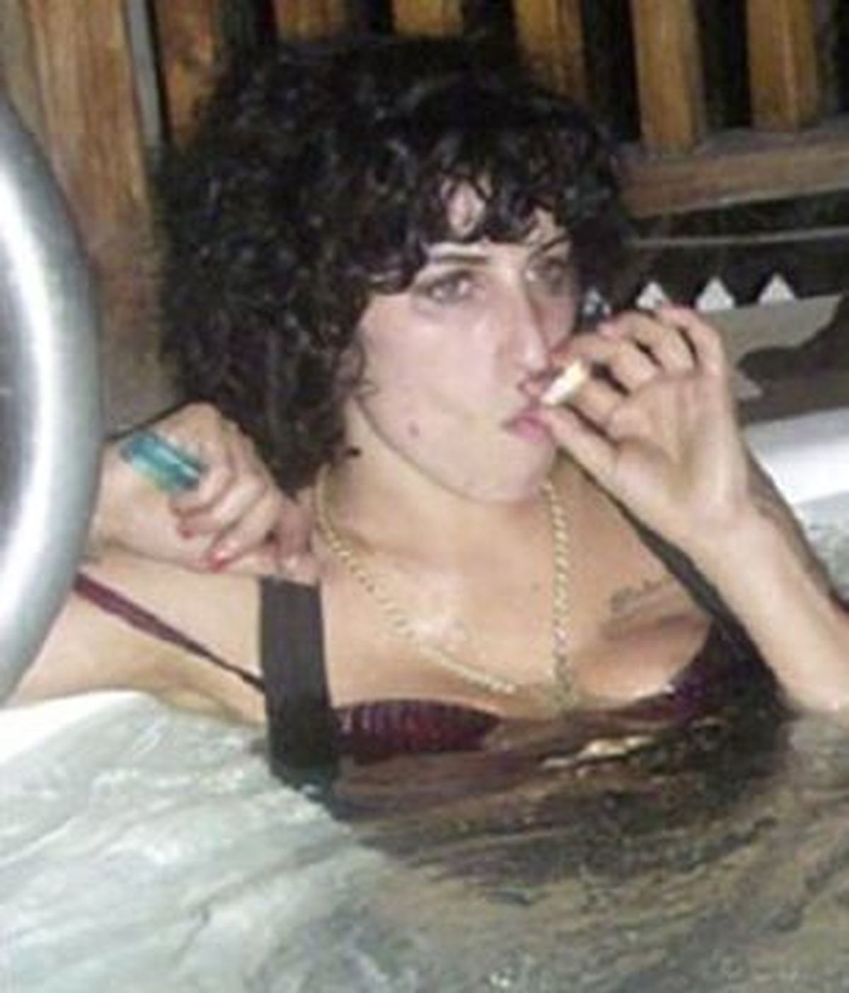 La foto que publica 'The Sun' que muestra a Amy Winehouse fumándose un porro, mientras se relaja en una piscina en la isla caribeña de Santa Lucía. Foto The Sun