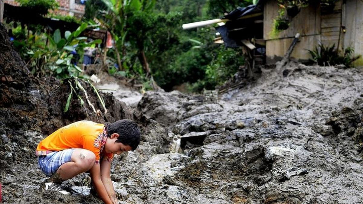 Un niño juega en medio de un alud de tierra en el municipio de Sabaneta (Colombia). Los damnificados por las lluvias caídas en el país durante el último año superan ya los tres millones, una cifra "histórica". EFE