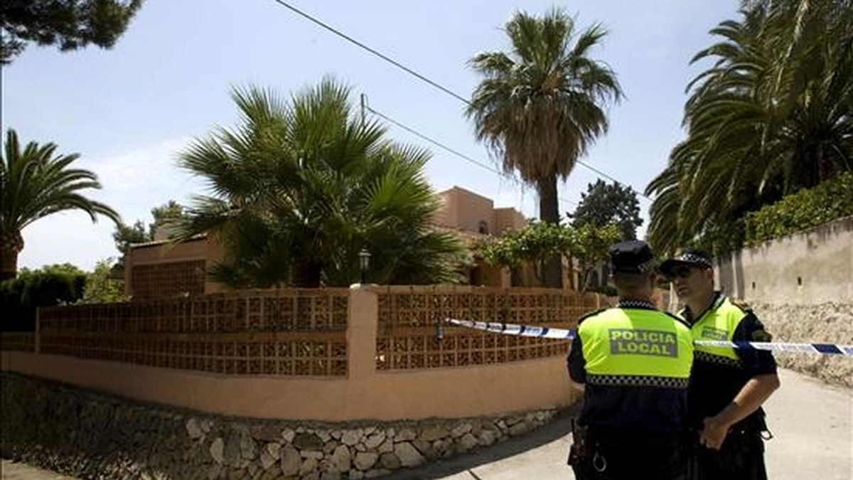 Dos policías municipales de Jávea (Alicante) controlan los accesos a la vivienda en la que un hombre de unos 30 años ha muerto tras ser agredido presuntamente por su compañero sentimental. EFE