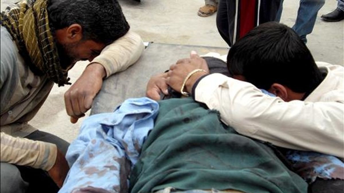Dos hombres lloran junto al cadáver de un familiar asesinado en la explosión de una bomba instalada en una motocicleta en el norte de Baquba, capital de la provincia de Diyala, al noreste de Bagdad, el 30 de marzo de 2009. Hoy un nuevo atentado en Mosul ha dejado 7 muertos. EFE