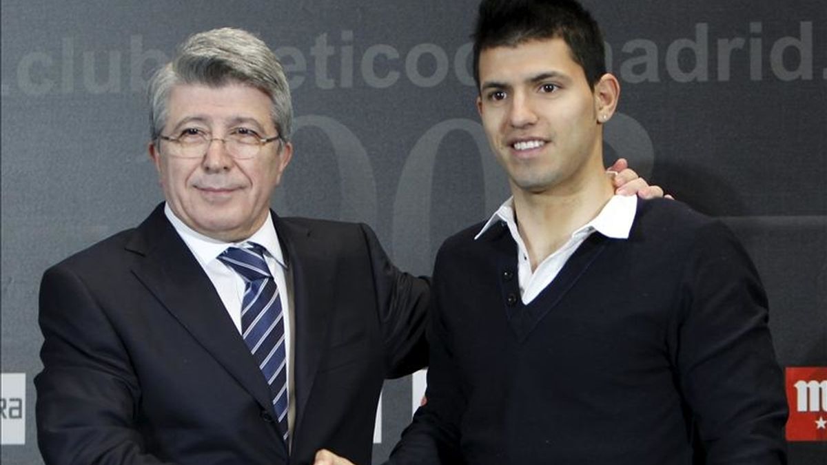 El delantero argentino Sergio "Kun" Agüero (d) posa junto al presidente del Atlético de Madrid, Enrique Cerezo, durante el acto en el que fue presentada su renovación con el club madrileño hasta el 30 de junio de 2014, hoy en el estadio Vicente Calderón. Vídeo: Informativos Telecinco. El delantero argentino Sergio "Kun" Agüero (d) posa junto al presidente del Atlético de Madrid, Enrique Cerezo, durante el acto en el que fue presentada su renovación con el club madrileño hasta el 30 de junio de 2014, hoy en el estadio Vicente Calderón. Vídeo: Informativos Telecinco.