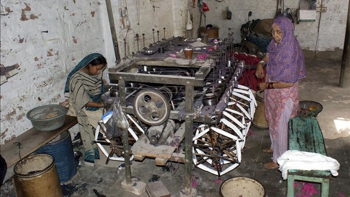 Artesanas tejen en un telar de un pequeño taller de Hyderabad, Pakistán. Según medios locales, el aumento del precio del hilo en los mercados locales ha forzado a miles de pequeños talleres a cerrar ante la imposibilidad de adquirir género. Esta crisis ha provocado despido de más de un millón de trabajadores. EFE
