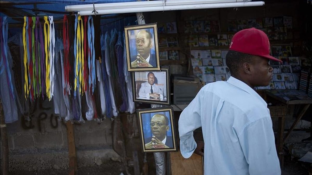 Un vendedor permanece junto a fotografías de los ex mandatarios haitianos Jean Claude Duvalier y Jean-Bertrand Aristide el pasado 25 de enero en Puerto Príncipe. EFE/Archivo