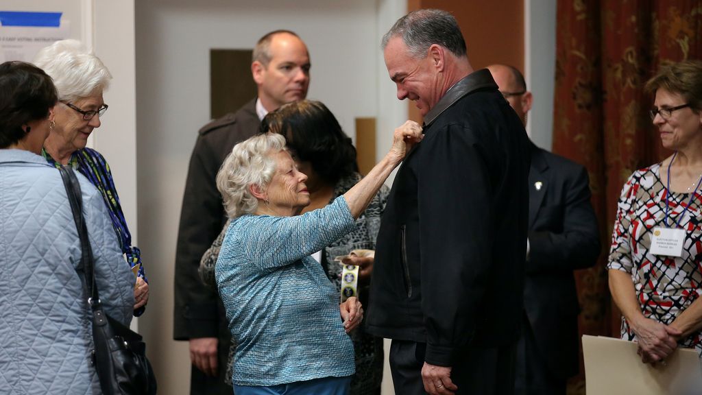 Una mujer pone la pegatina 'Yo voto' a Tim Kaine