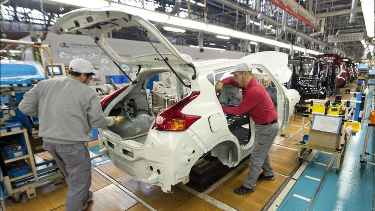 Dos empleados trabajan en una cadena de montaje de Nissan. EFE/Archivo