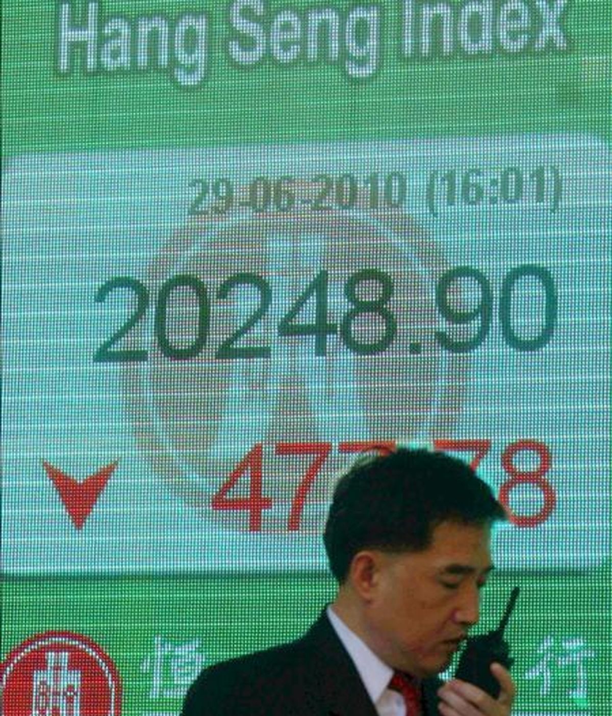 Un hombre pasa delante de un panel electrónico de una sucursal bancaria de Hong Kong (China) que muestra el valor alcanzado por el índice Hang Seng de la Bolsa de Hong Kong. EFE/Archivo