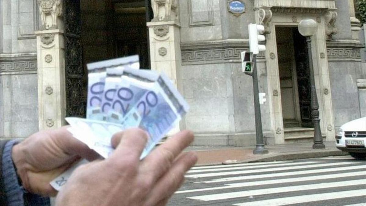 Un hombre muestra billetes de euro retirados de un cajero automático. EFE/Archivo