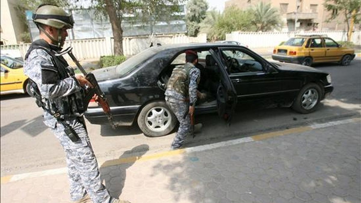 Policías iraquíes inspeccionando un vehículo en un punto de control del centro de Bagdad este martes. EFE
