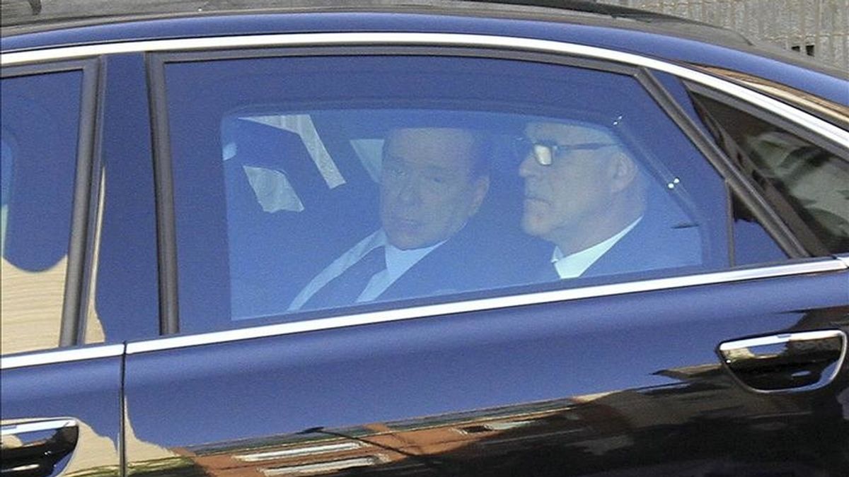El primer ministro italiano, Silvio Berlusconi (i), llega a bordo de un coche oficial al Tribunal Penal de Milán (Italia), el pasado 11 de abril. EFE