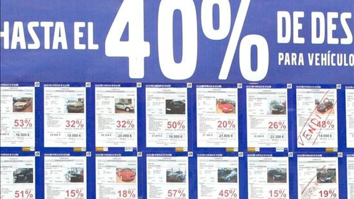 Un concesionario de vehículos con un cartel anunciando grandes decuentos por la compra de turismos y todoterrenos. EFE/Archivo
