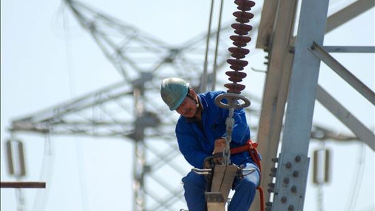 Un trabajador instala nuevas líneas de alto voltaje en una torre de electricidad. EFE/Archivo