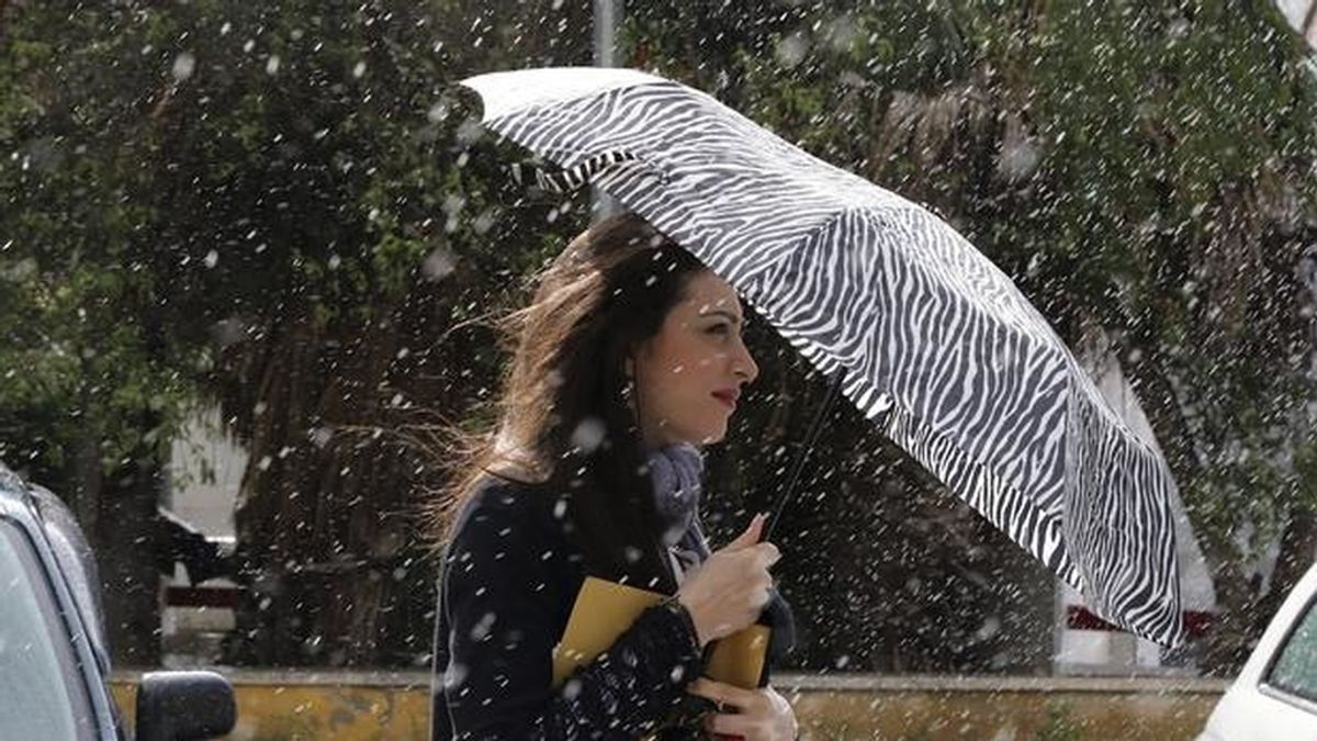 Una mujer se protege de la lluvia