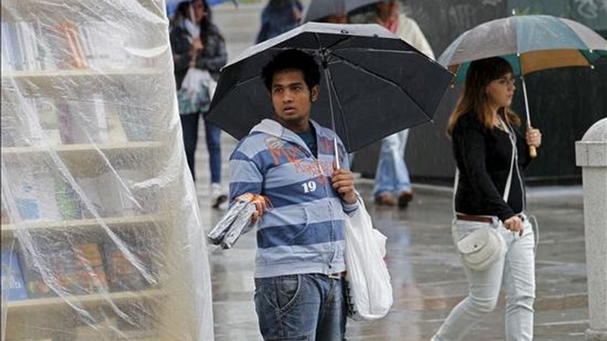 Un vendedor callejero ofrece paraguas a los viandantes en una calle de Madrid. EFE/Archivo