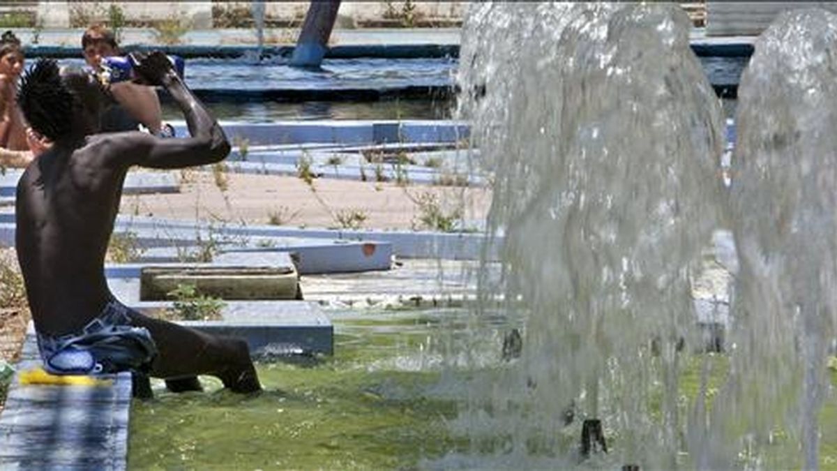 Una persona se refresca en una fuente céntrica de Sevilla. EFE