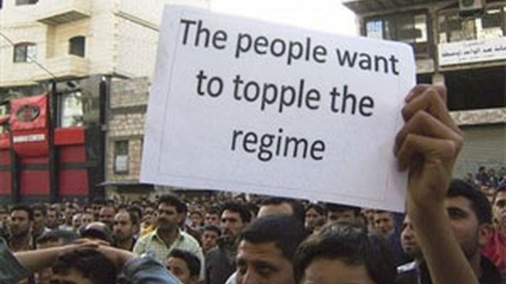 Un grupo de manifestantes en Siria muestran un cartel en el que puede leerse: "la gente quiere derrocar el régimen". Foto: AP. Un grupo de manifestantes en Siria muestran un cartel en el que puede leerse: "la gente quiere derrocar el régimen". Foto: AP.