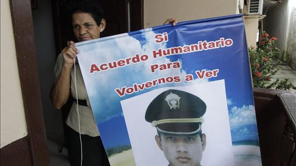 Noemí Julio de Solórzano, madre del mayor de la Policía Guillermo Solórzano, sostiene un aviso con la imagen de su hijo en Cartagena, Colombia. Las FARC anunciaron que liberarán sin condiciones a cinco secuestrados como "gesto de humanidad" hacia la ex senadora colombiana Piedad Córdoba, destituida recientemente por supuestos nexos con esa guerrilla. EFE
