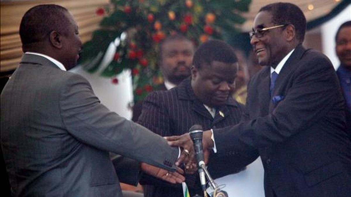 El líder del partido opositor zimbabuense Movimiento por el Cambio Democrático, Morgan Tsvangirai (izq), es felicitado por el presidente zimbabuense, Robert Mugabe (dcha) tras jurar el cargo como nuevo primer ministro en Harare (Zimbabue) hoy miércoles 11 de febrero. EFE