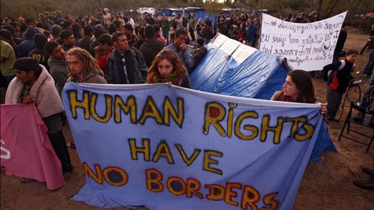 Inmigrantes portan una pancarta con el mensaje "los derechos humanos no tienen fronteras", horas antes de la operación de desmantelamiento de un campamento de inmigrantes indocumentados en los alrededores del puerto de Calais (noroeste de Francia). EFE/Archivo