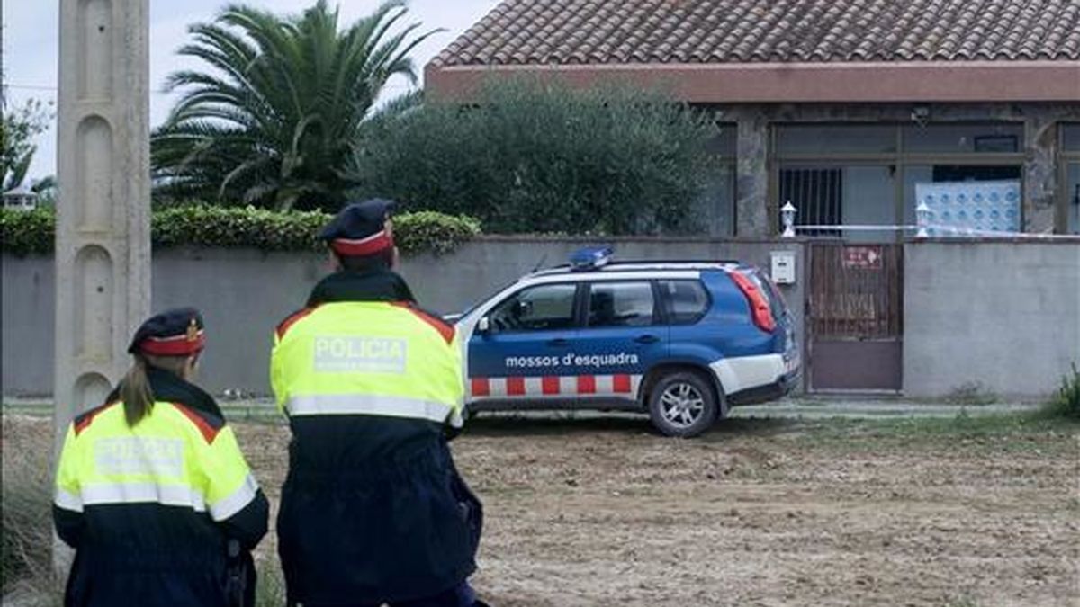 Efectivos de la policía autonómica ( Mossos d'Esquadra ), hacen guardía ante la vivienda donde se encontró ayer a una mujer muerta descuartizada en un congelador en Sant Pere Pescador (Girona). EFE