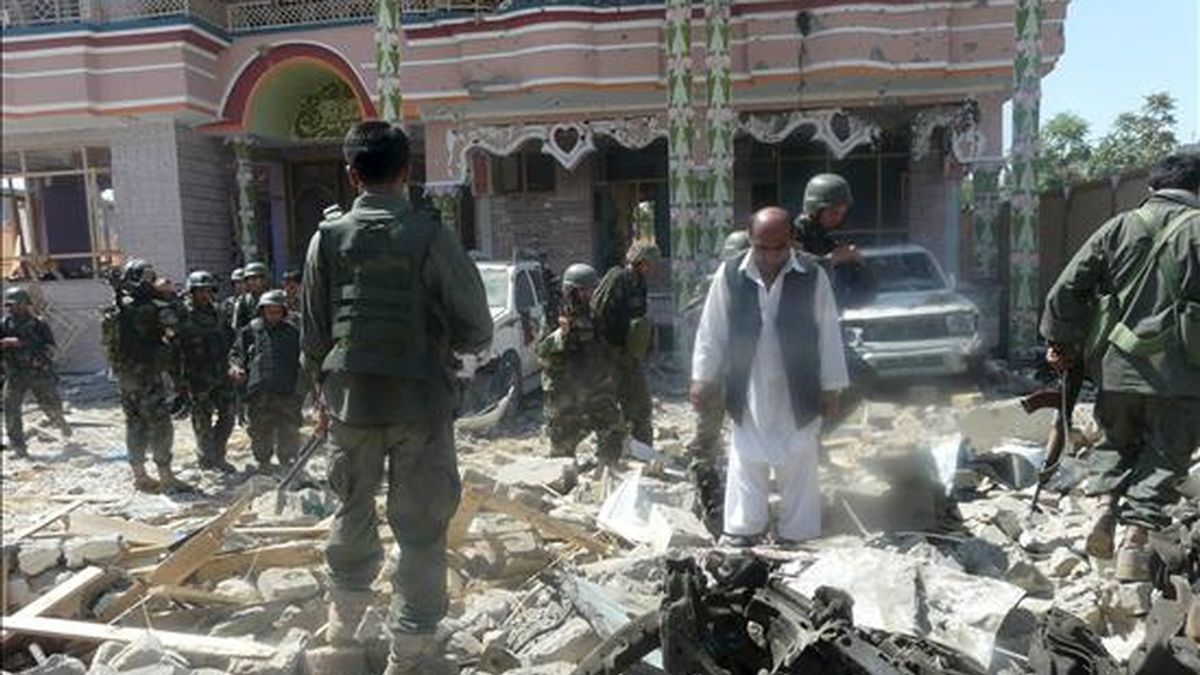 Soldados afganos inspeccionan un edificio incendiado por el ataque de un comando talibán contra las oficinas de una agencia de desarrollo estadounidense (USAID) en la ciudad de Kunduz, Afganistán, hoy, viernes, 2 de julio de 2010. EFE