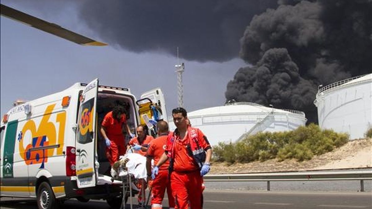 Miembros del 061 evacúan a uno de los operarios que resultaron heridos de diversa consideración en un incendio registrado ayer  en la Refinería La Rábida de CEPSA en Palos de la Frontera (Huelva). EFE