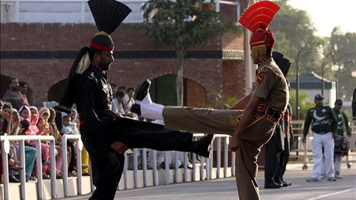 Fotografía de archivo tomada el 31 de mayo de 2010 que muestra a un soldado indio de la Fuerza de Seguridad de la Frontera y a otro de las fuerzas paquistaníes durante la ceremonia militar "Beating the Retreat", de origen británico, en el puesto fronterizo de Attari. EFE