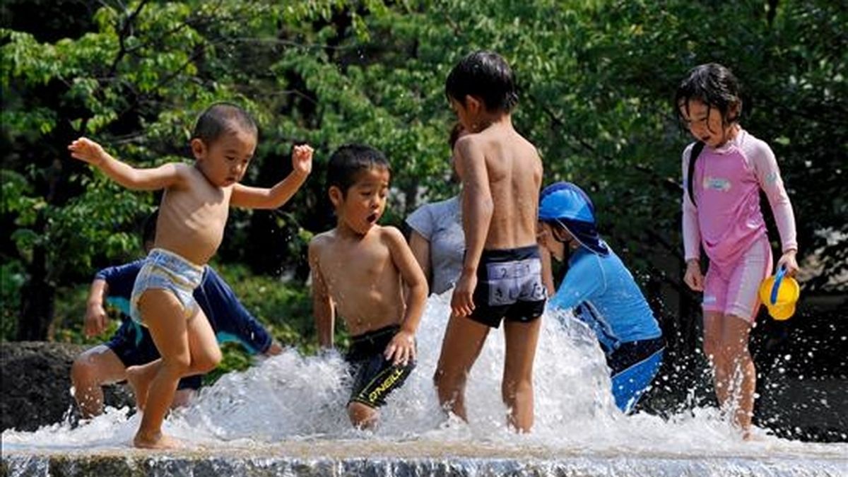 Un grupo de niños juega con el agua en una fuente en el centro de Tokio (Japón). EFE/Archivo