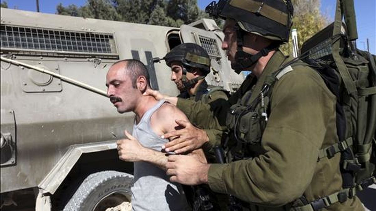 Soldados israelíes detienen a un manifestante palestino durante una protesta contra el muro de separación israelí, en la población de Maasarah, cerca de Belén (Cisjordania). EFE/Archivo