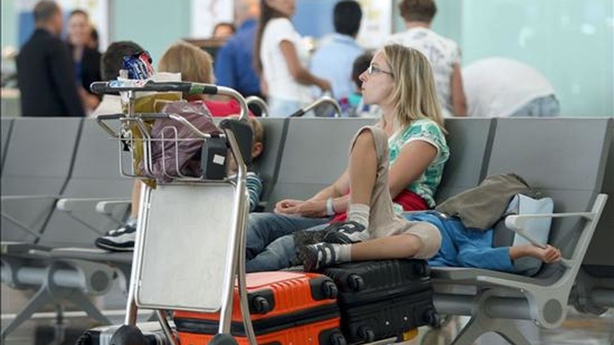 Una familia espera en la Terminal 1 del aeropuerto de El Prat (Barcelona). EFE/Archivo