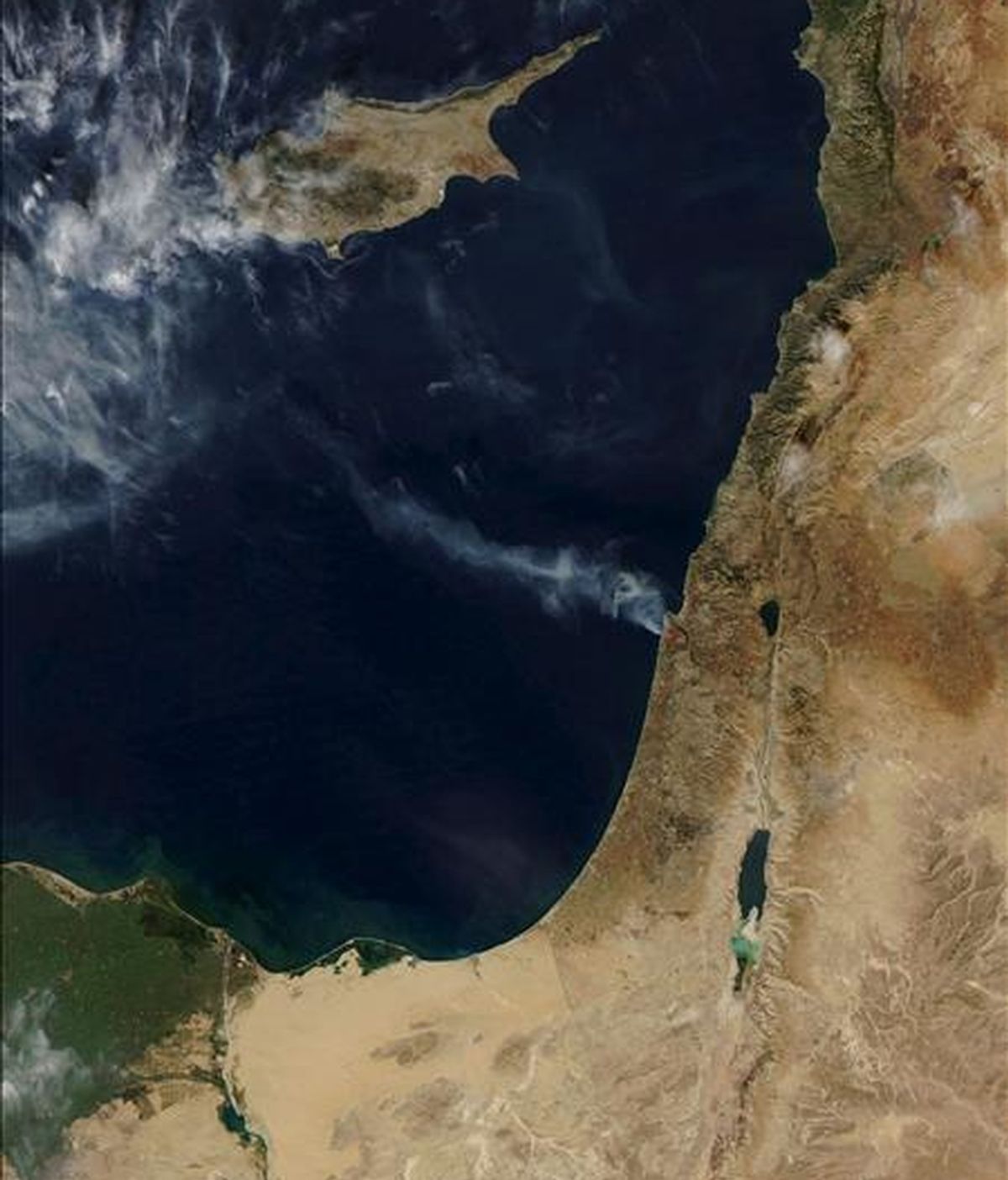 Fotografía facilitada por la NASA y tomada con el Espectrorradiómetro de Imágenes (MODIS, por su sigla en inglés) del satélite Agua, muestra la estela de un incendio forestal en Israel (parte superior derecha), el 3 de diciembre de 2010. EFE