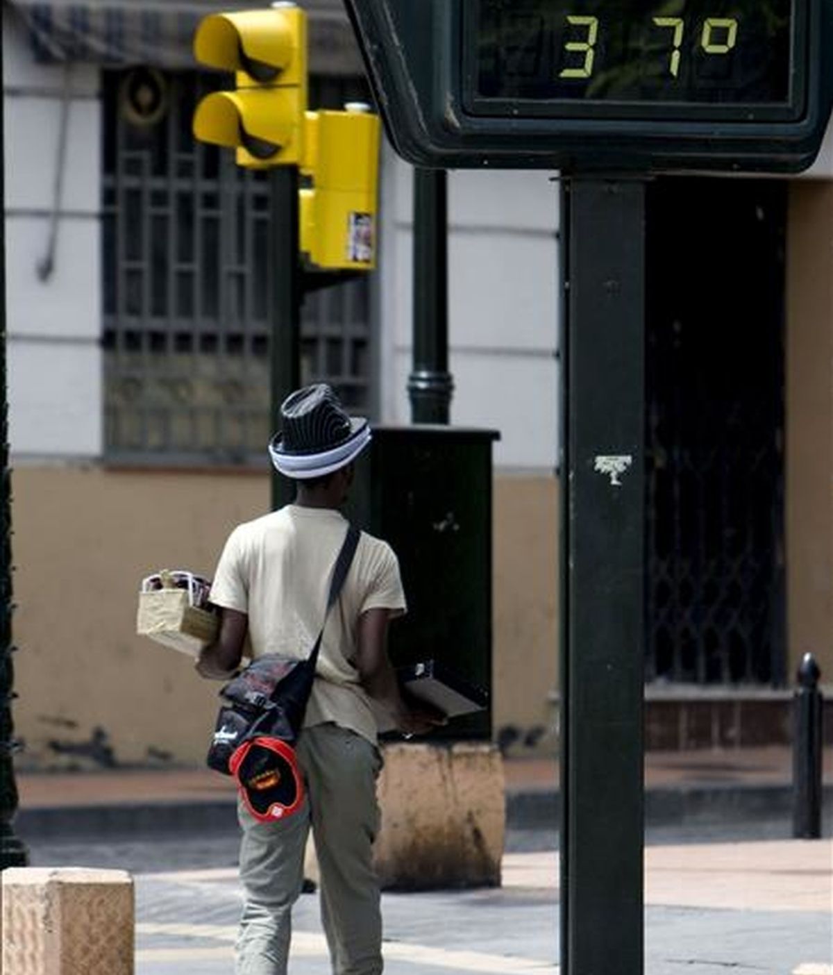 Un vendedor ambulante pasea bajo un termómetro en el casco histórico de Zaragoza. EFE