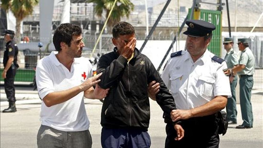 Una de las once personas que han sido interceptadas hoy en una patera a unas 40 millas mar adentro a la altura de Benidorm (Alicante) es atendido por voluntarios de Cruz Roja y de la Policía Nacional a su llegada al Puerto de Alicante. EFE
