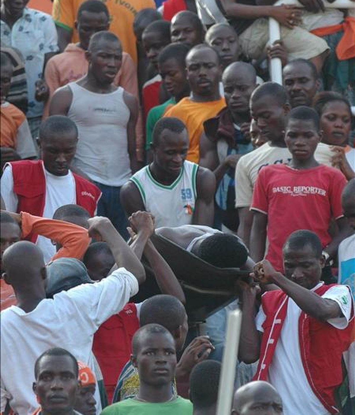 Varios hombres retiran de las gradas en camilla a un espectador herido en la avalancha humana que se registró entre los espectadores que acudían al partido de la fase de clasificación para la Copa del Mundo Sudáfrica 2010 entre Costa de Marfil y Malawi, en Abidjan (Costa de Marfil). EFE
