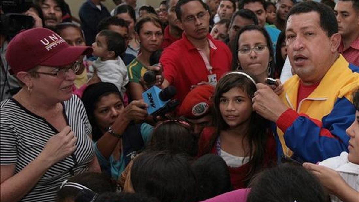 El presidente venezolano, Hugo Chávez (d), habla ante un grupo de damnificados por las lluvias en Palo Negro, Aragua (Venezuela). Chávez pidió que el Parlamento redacte una ley que permita a su Gobierno disponer de terrenos para construir viviendas para familias afectadas. EFE