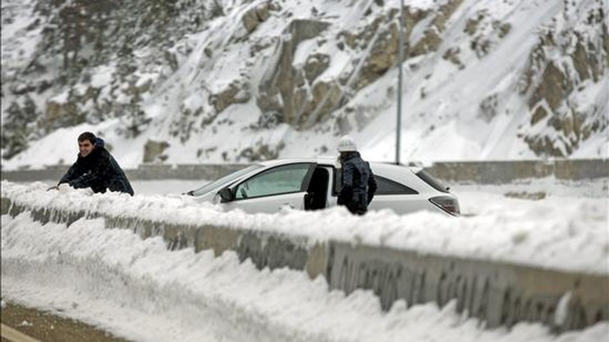 Varias personas disfrutando de la nieve junto a una carretera de Navacerrada (Madrid). El Ayuntamiento de Madrid ha activado el Plan Nevada 2010-2011 para coordinar las actuaciones ante las nevadas previstas en la capital. EFE
