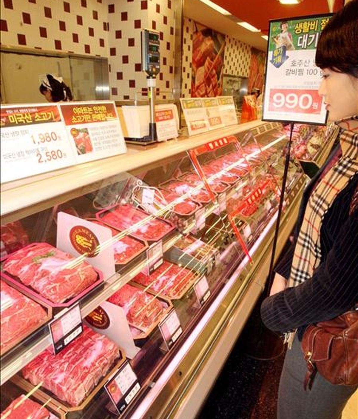 Una compradora observa bandejas con carne en un supermercado. EFE/Archivo