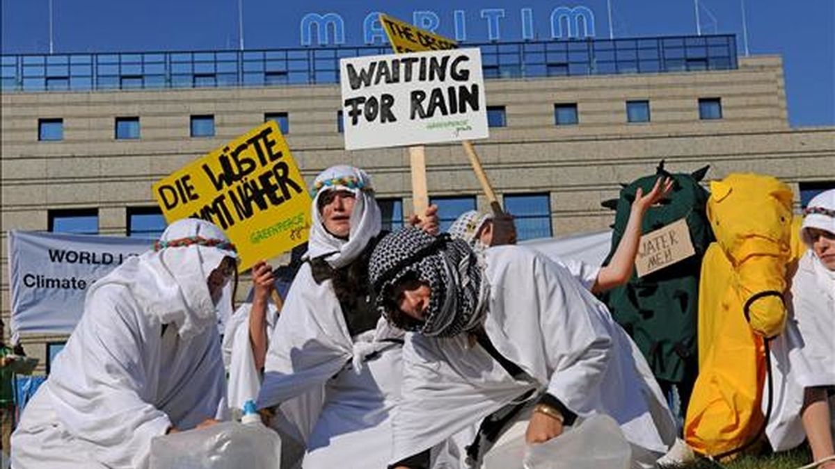 Activistas de Greenpeace disfrazados de beduinos simulan estar desesperados por la carencia de agua, durante una protesta celebrada hoy a las afueras del Hotel Maritim en Bonn, Alemania. EFE