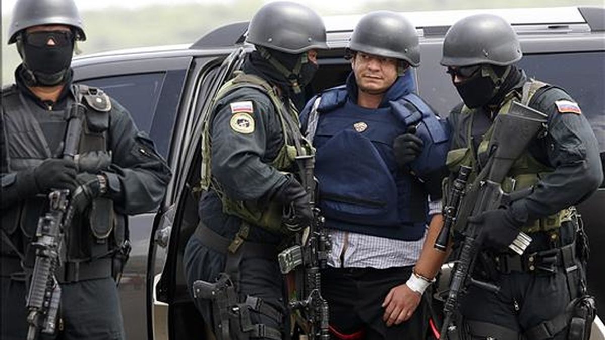 El salvadoreño Francisco Chávez Abarca (c), solicitado por Interpol por delitos de terrorismo es custodiado en el aeropuerto caraqueño de Maiquetía (Venezuela), antes de abordar el avión para su traslado a Cuba. EFE