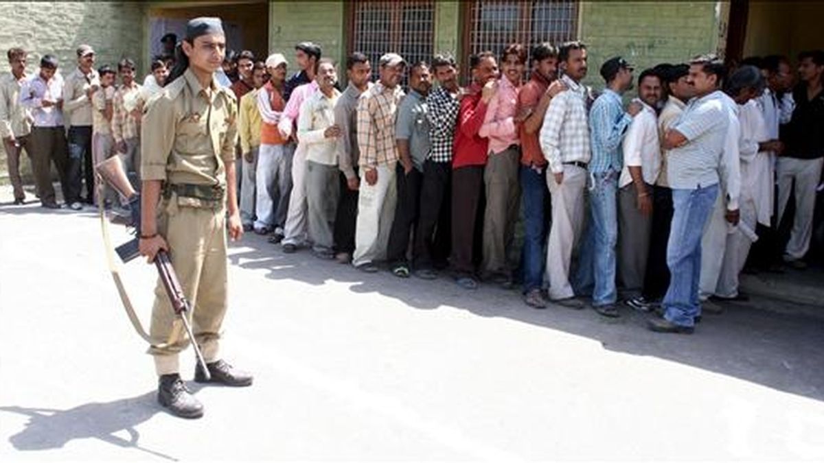 Un policía hace guardia en el extrior de un colegio electoral del pueblo indio de Suchit Garh. EFE