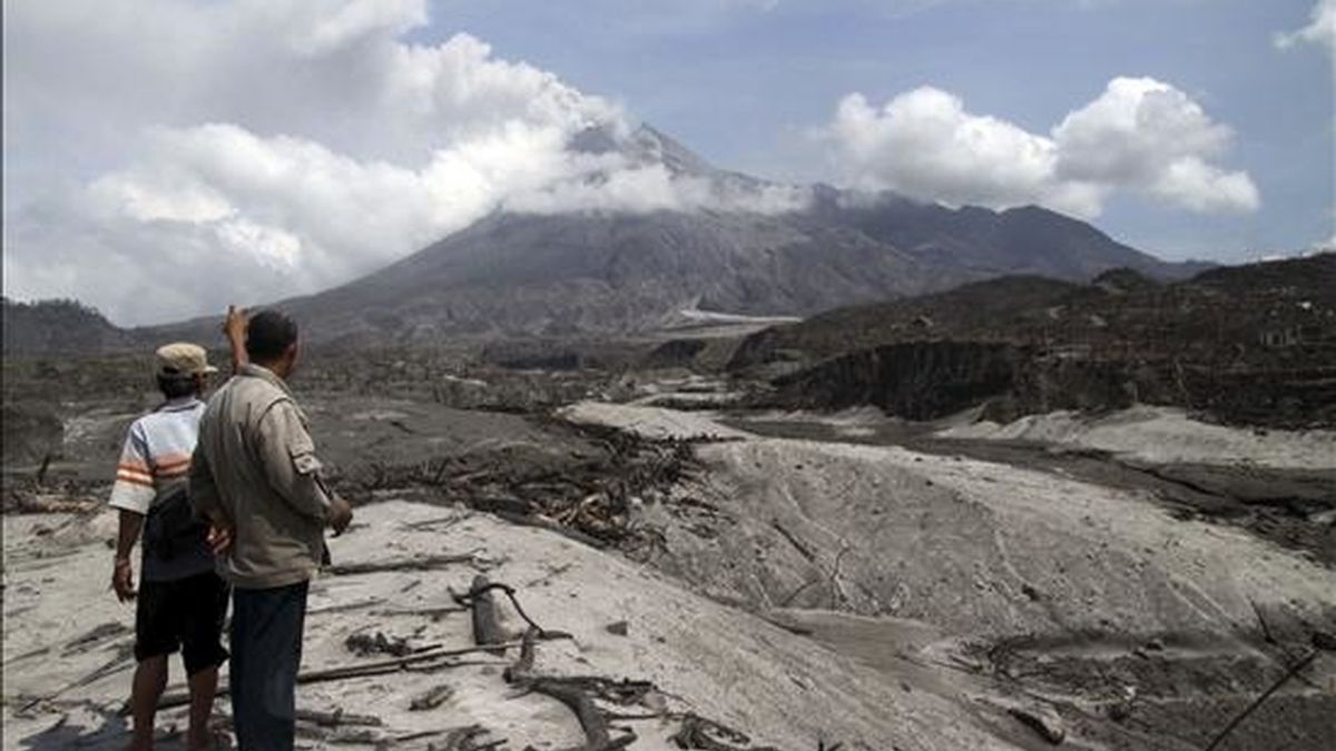 Dos personas miran hacia el volcán Merapi, en la aldea de Glagaharjo, en Sleman, Indonesia, el pasado 20 de noviembre. EFE/Archivo