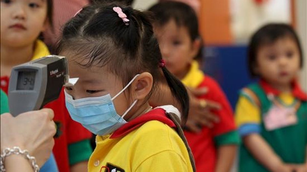 Una profesora toma la temperatura a una niña en una guardería de Hong Kong (China). EFE/Archivo