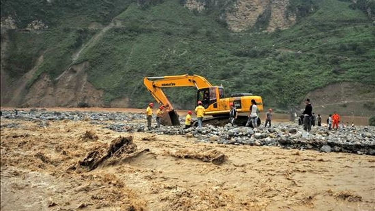Una máquina excavadora remueve los cantos rodados arrastrados por la corriente, en la población de Xiaohe, en la provincia china de Yunnan, tras las lluvias torrenciales caidas el 14 de julio. EFE/Archivo
