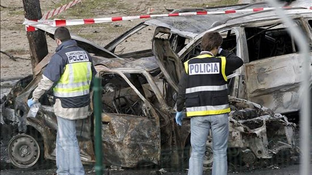 Dos agentes de policía observan los coches destrozados por la explosión de un coche bomba ocurrida esta mañana en el Campo de las Naciones de Madrid, en la que no ha habido víctimas. EFE