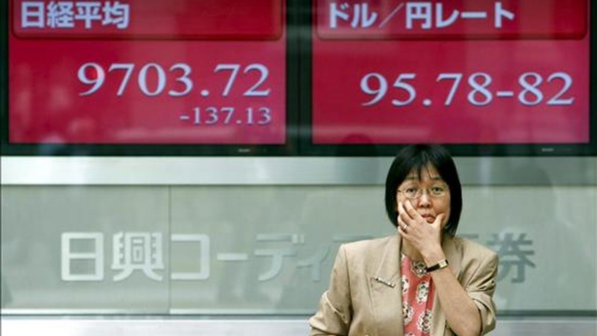 Una mujer japonesa delante de una pantalla de información bursátil en Tokio. EFE
