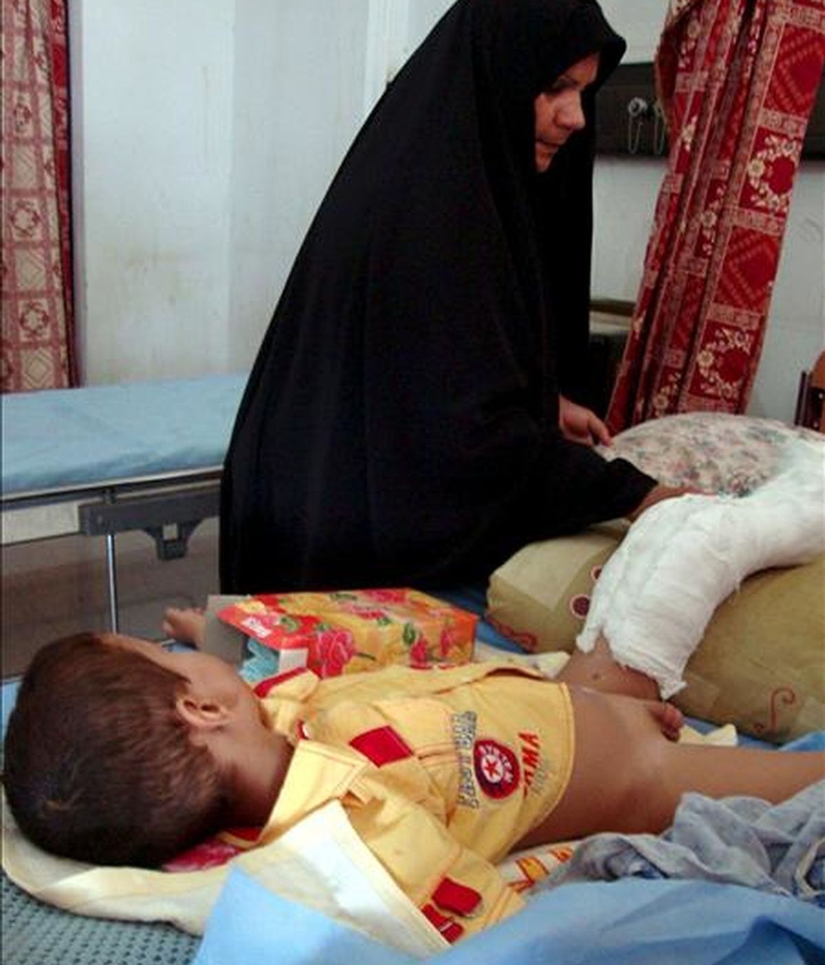 Una mujer iraquí acompañando en un hospital de Nayaf a su hijo, herido el pasado lunes en un atentado con coche bomba en Kerbala (Irak). EFE