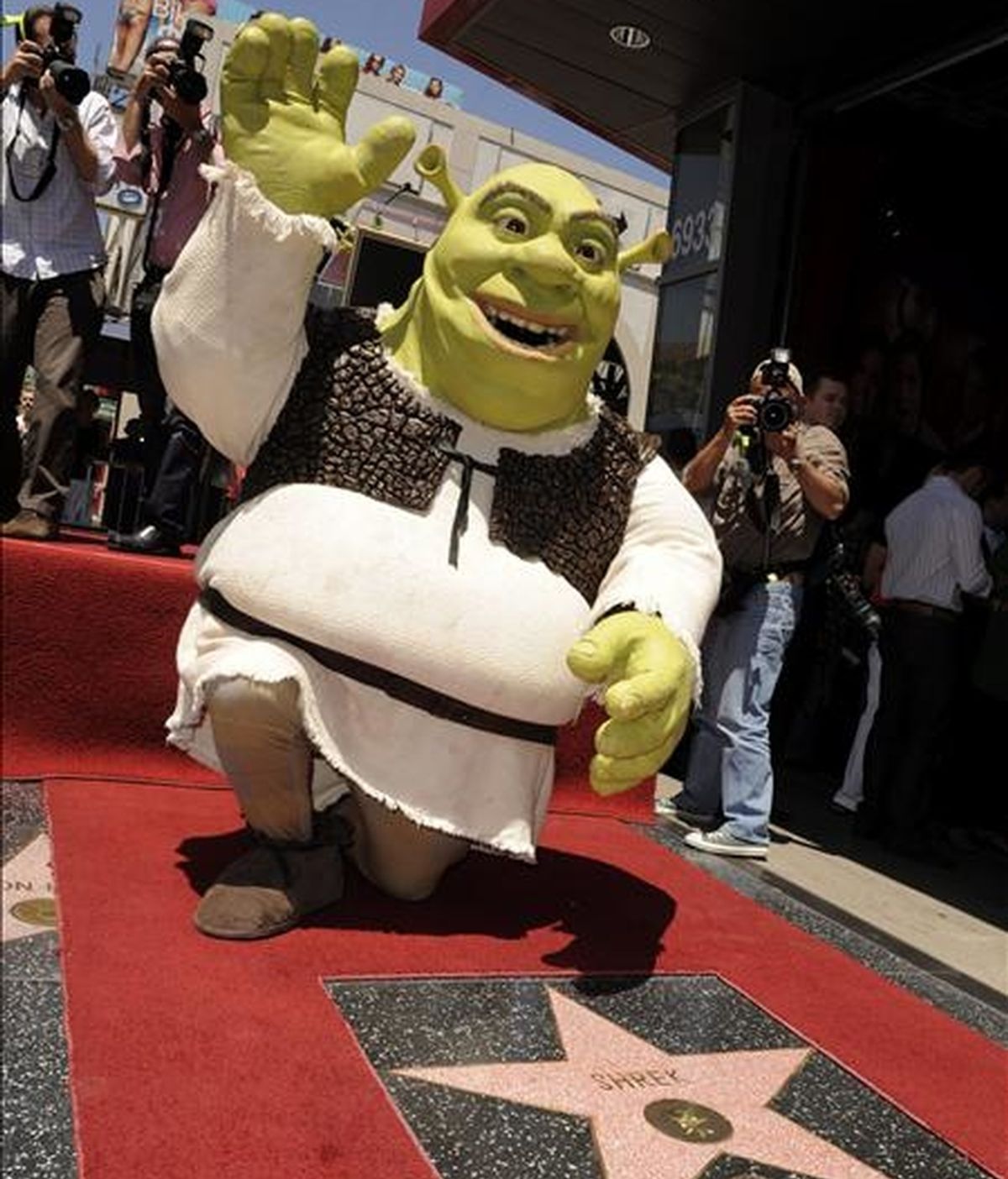 Shrek, la estrella de las películas animadas, saluda al público al recibir la estrella número 2.408 en el paseo de la fama de Hollywood (EEUU). La saga, que ha ganado el premio Óscar a la mejor cinta animada, llega a su cuarta parte, que será estrenada mañana en España. EFE/Archivo