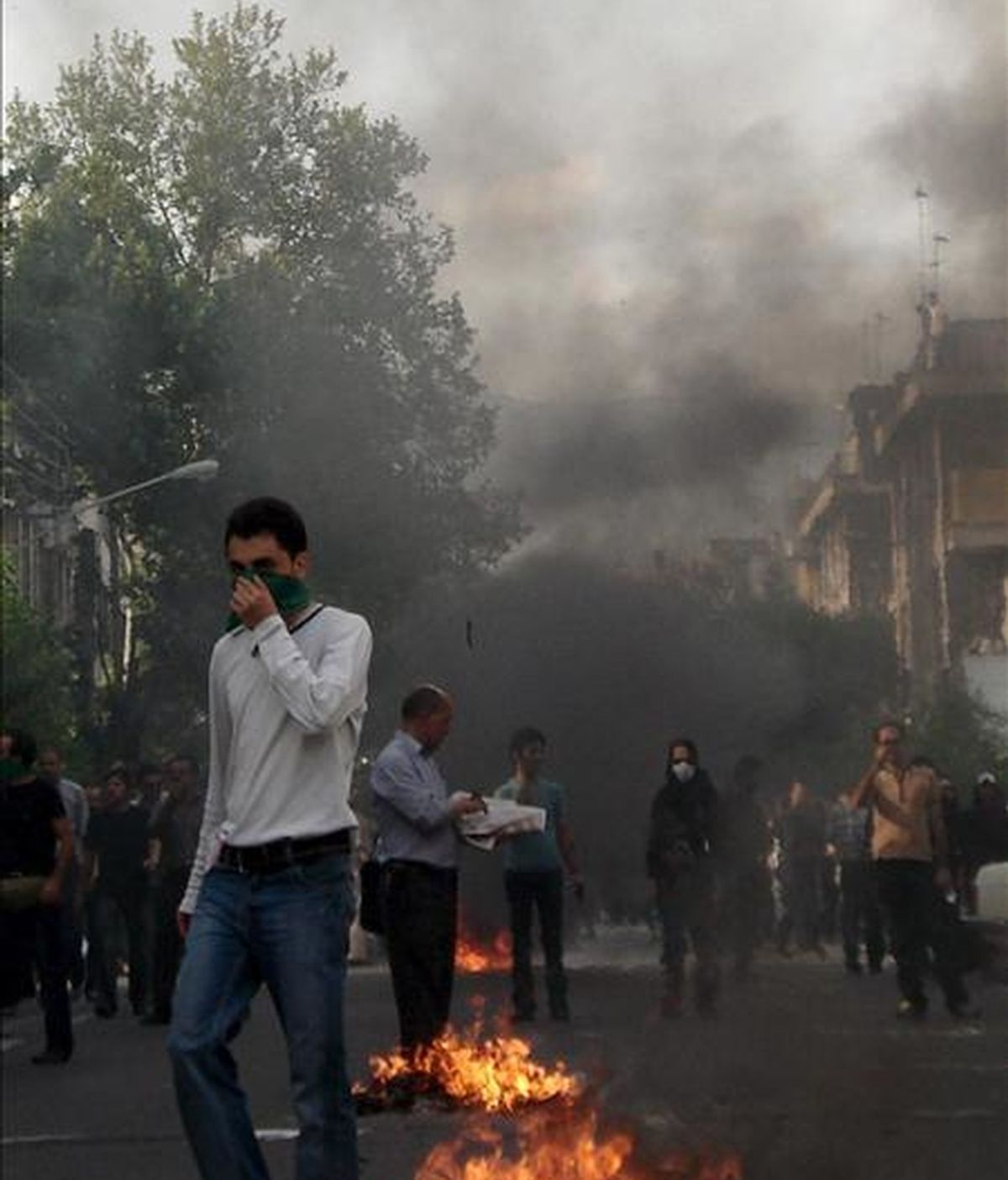 Fotografía recibida a través de Demotix Images en las que se obseva a un manifestante en medio del humo y el fuego provocado tras las protestas de la oposición en Teherán. EFE