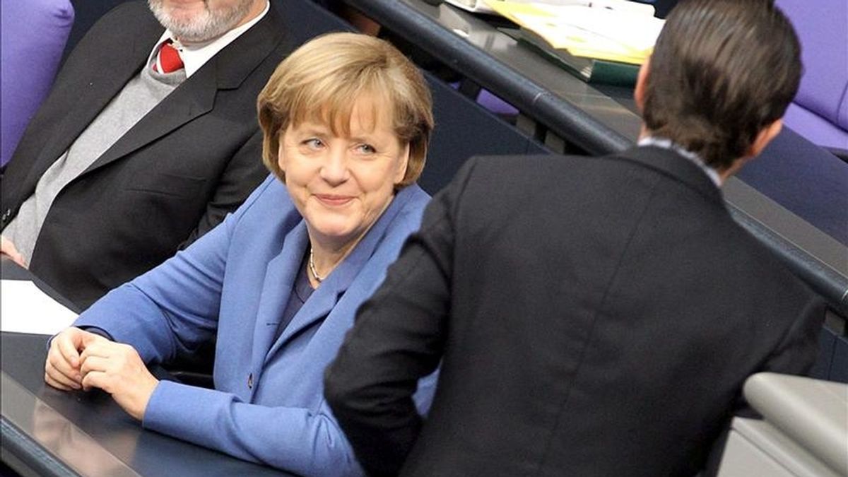 La canciller alemana, Angela Merkel, sonríe al ministro de Defensa Karl-Theodor zu Guttenberg, durante un debate en el Bundestag (Parlamento alemán). EFE/Archivo