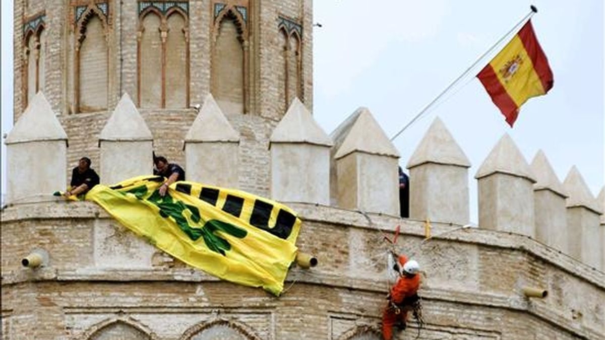 Activistas de Greenpeace han intentado colocar hoy una pancarta en la Torre del Oro de Sevilla, con el lema 'Cerrado por cambio climático', lo que ha sido impedido por la policía. EFE